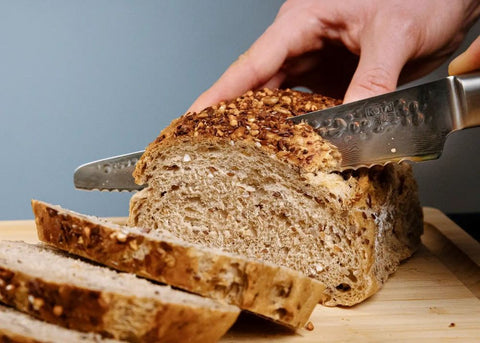 bruin brood snijden met kotai pakka damascus broodmes 20 cm pakkahout op snijplank