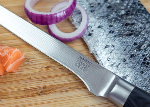 kotai pakka damascus fileermes 20 cm pakkahout op houten snijplank met zalm en rode ui