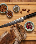kotai pakka damascus broodmes 20 cm pakkahout op houten snijplank met brood