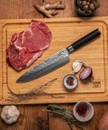 kotai pakka damascus koksmes gyuto 20 cm pakkahout op houten snijplank met vlees en ui